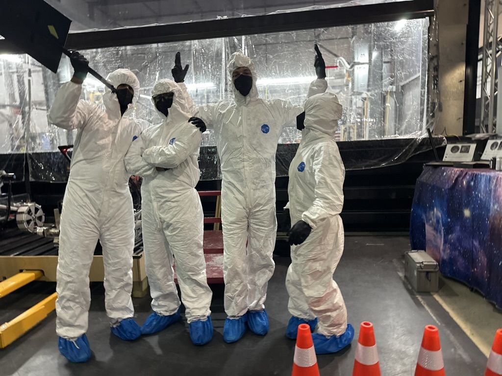Pit crew in clean-room suits at the competition arena