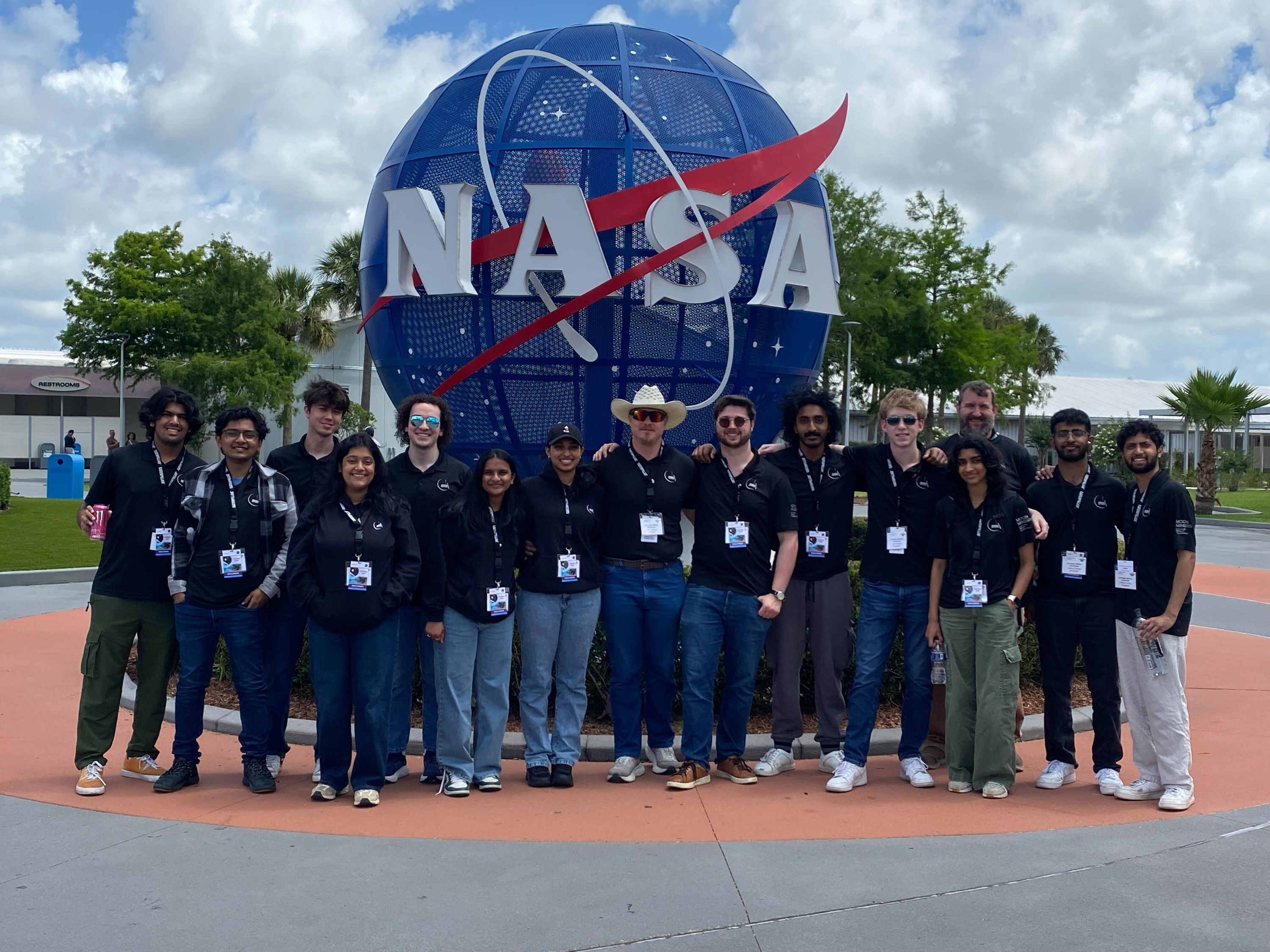 Moon Miners with their award in front of the NASA globe at Kennedy Space Center